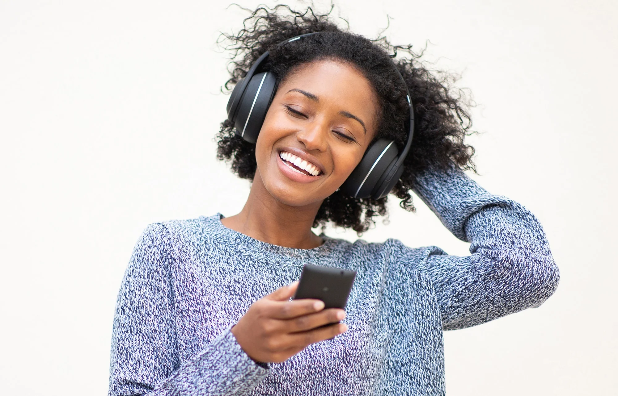 Cosmetic Dentist 12 A woman listening to music on her headphones and smiling.