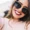 A woman with sunglasses smiling.