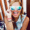 A woman with sunglasses smiling at the beach.
