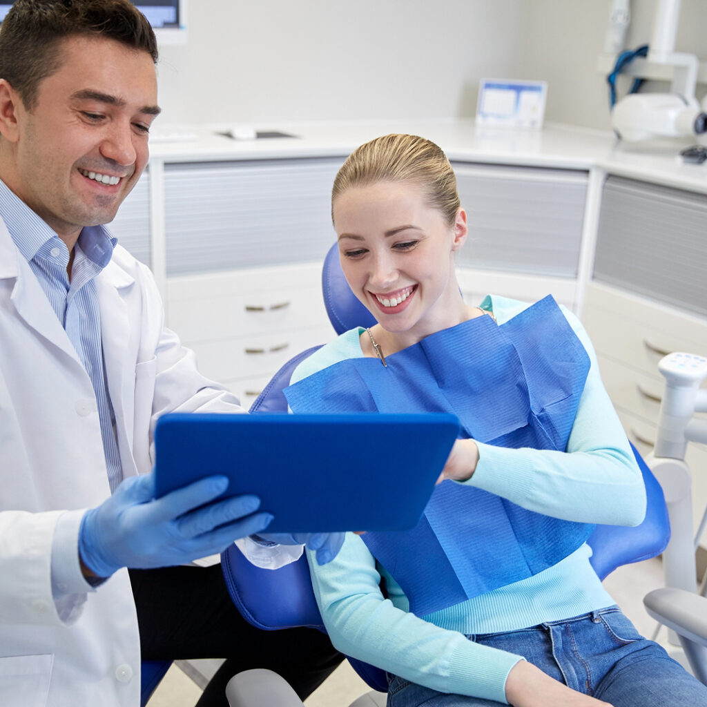 a dental professional explaining something to a female patient