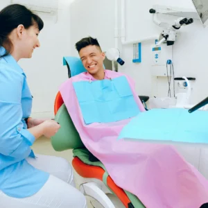 Blog 6 a smiling patient sitting in a dental chair with the dentist next to him