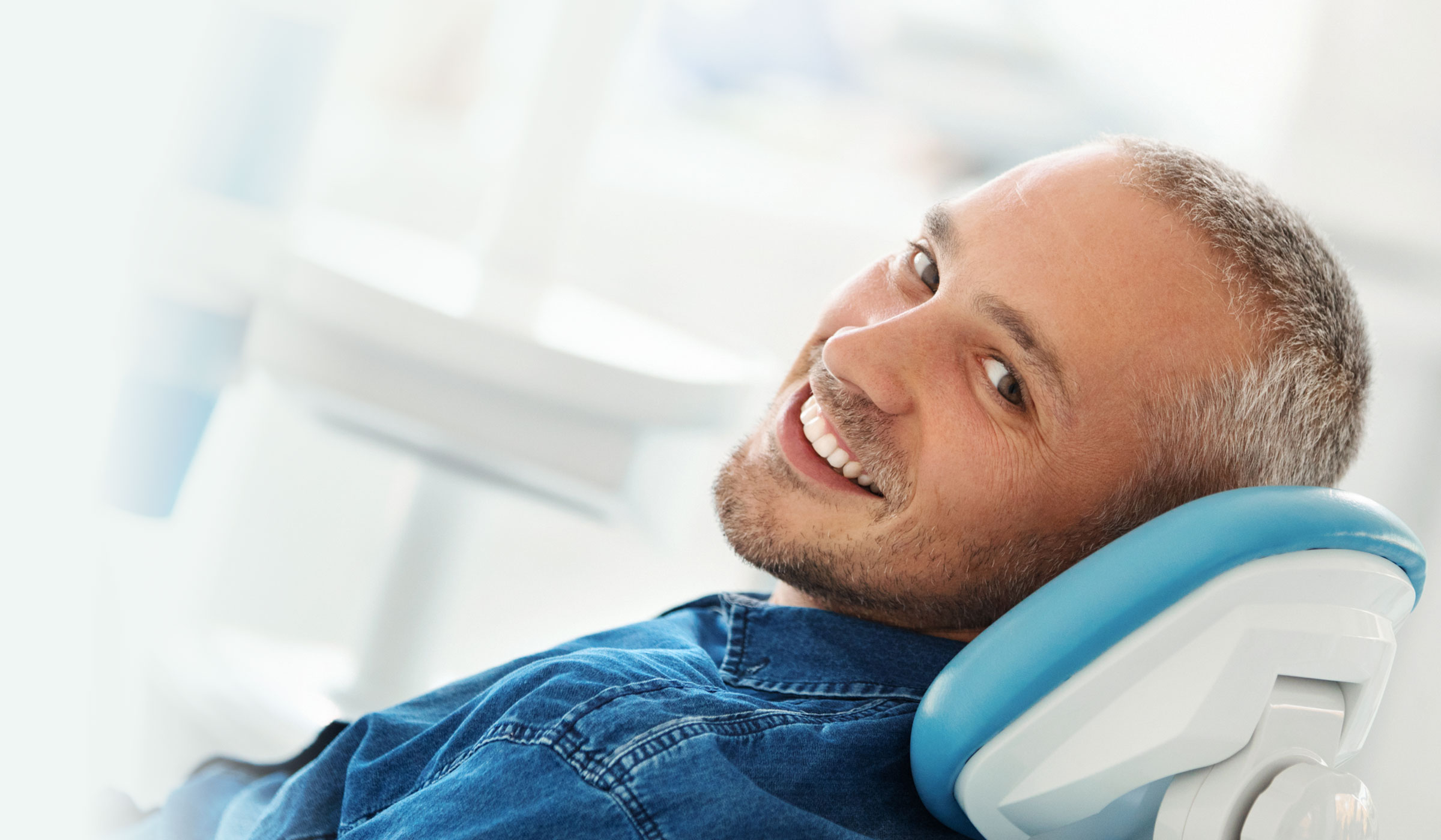 a man smiling in a dental chair