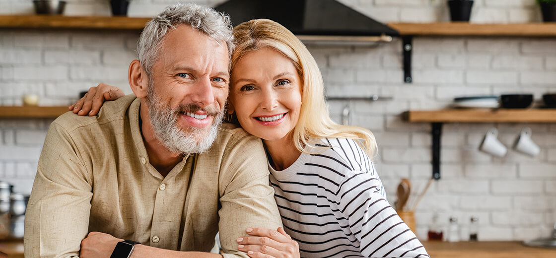 a smiling man and a woman with dentures