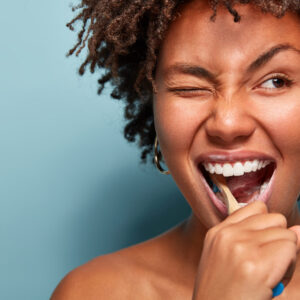 Patient demonstrating proper brushing technique at dental office in Whittier CA